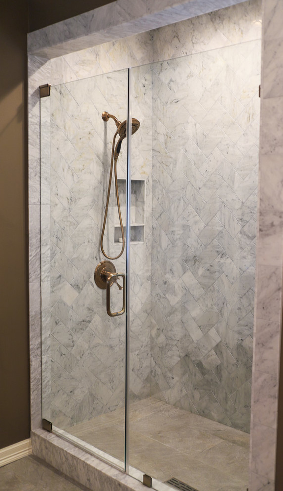 Corner shower - large transitional master white tile and marble tile porcelain tile and gray floor corner shower idea with shaker cabinets, dark wood cabinets, an undermount tub, a one-piece toilet, brown walls, an undermount sink, quartz countertops, a hinged shower door and white countertops
