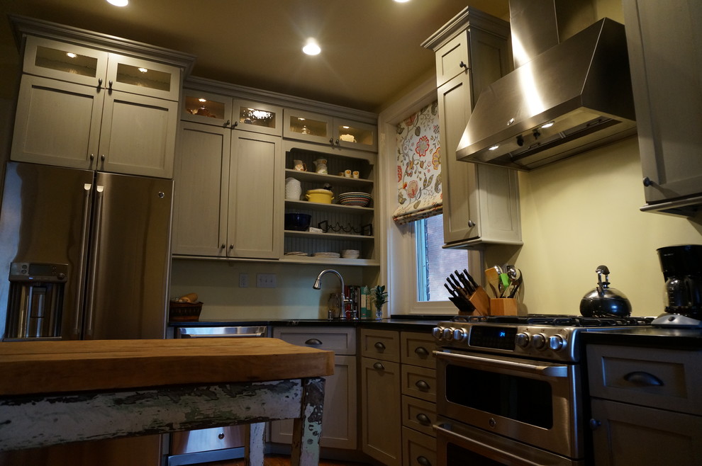 На фото: угловая кухня в классическом стиле с обеденным столом, врезной мойкой, фасадами в стиле шейкер, серыми фасадами, столешницей из талькохлорита и техникой из нержавеющей стали