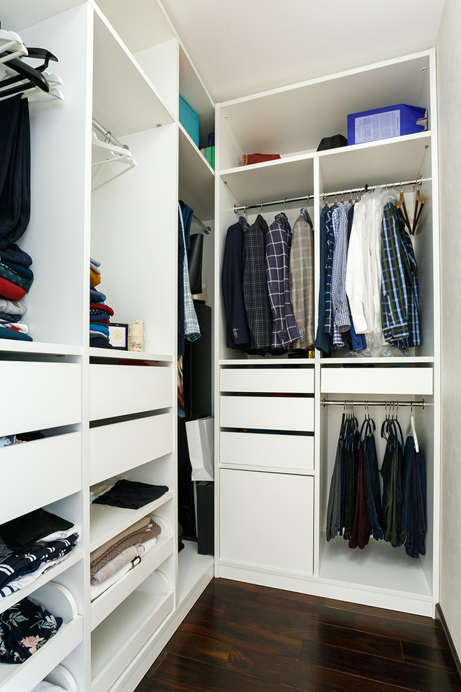 Photo of a mid-sized contemporary gender-neutral walk-in wardrobe in Moscow with open cabinets, white cabinets, dark hardwood floors and brown floor.