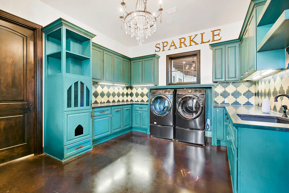 Inspiration for a mediterranean u-shaped dedicated laundry room in Austin with an undermount sink, raised-panel cabinets, blue cabinets, white walls, concrete floors, a side-by-side washer and dryer and brown floor.