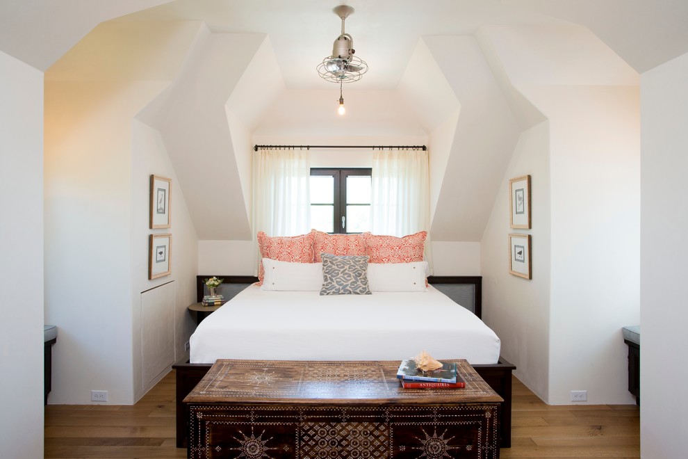 Example of a beach style medium tone wood floor bedroom design in Charleston with white walls
