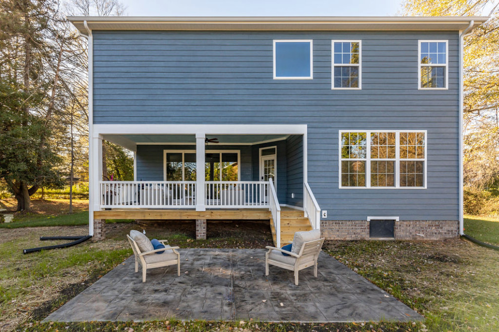 Стильный дизайн: двухэтажный, деревянный, синий частный загородный дом среднего размера в классическом стиле с плоской крышей, крышей из смешанных материалов, черной крышей и отделкой планкеном - последний тренд
