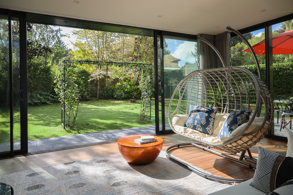 Idee per una grande veranda design con pavimento in bambù e lucernario