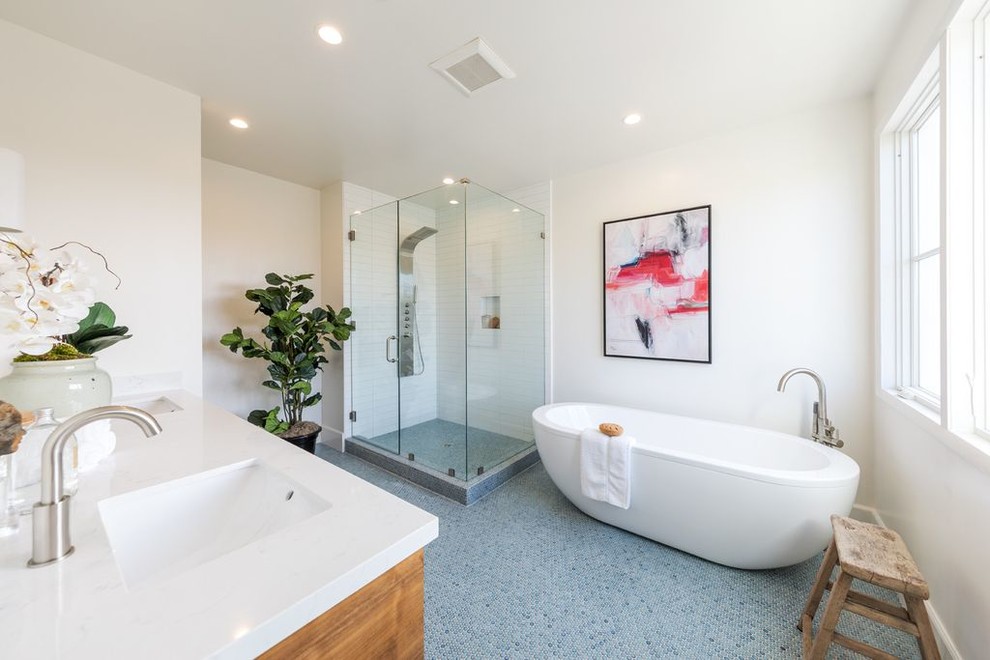This is an example of a country master bathroom in Los Angeles with medium wood cabinets, a freestanding tub, a corner shower, white tile, subway tile, white walls, mosaic tile floors, an undermount sink, blue floor, a hinged shower door and white benchtops.