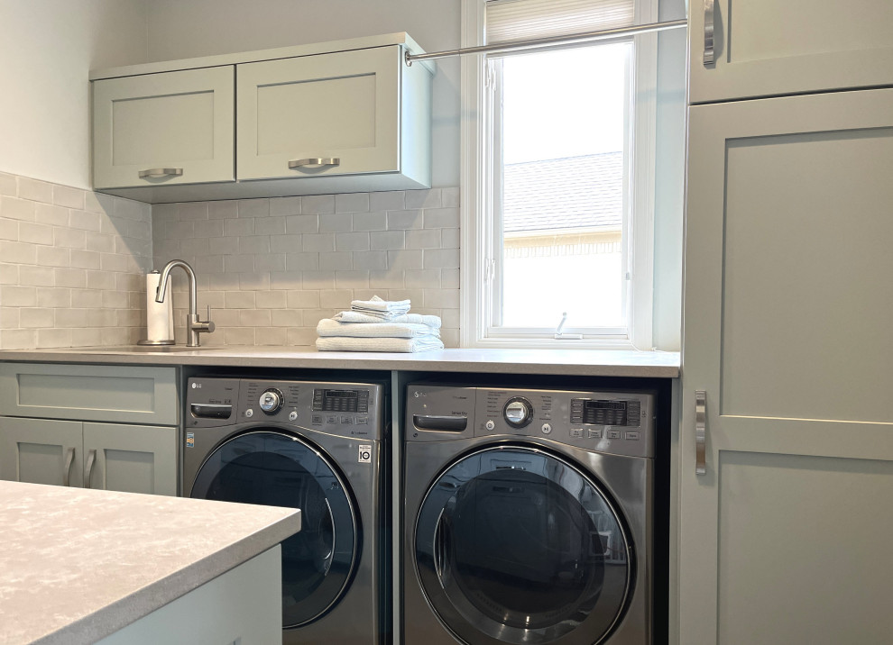 This is an example of a large galley dedicated laundry room in Detroit with an undermount sink, shaker cabinets, turquoise cabinets, quartz benchtops, white splashback, subway tile splashback, white walls, porcelain floors, a side-by-side washer and dryer, grey floor and grey benchtop.