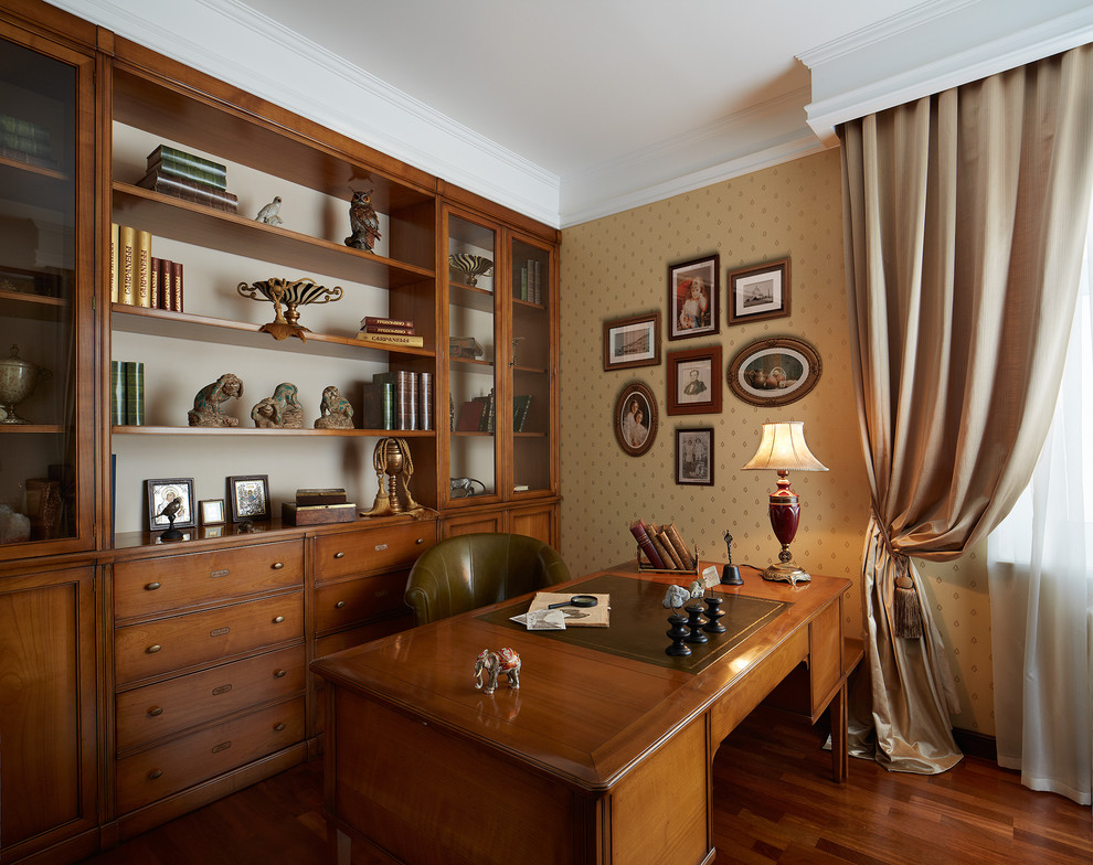 Diseño de despacho de tamaño medio sin chimenea con paredes beige, suelo de madera en tonos medios y escritorio independiente