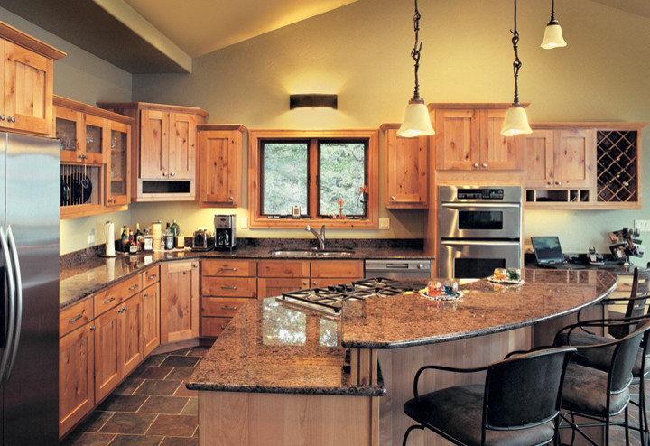 Design ideas for a mid-sized traditional l-shaped open plan kitchen in Seattle with a double-bowl sink, shaker cabinets, light wood cabinets, granite benchtops, stainless steel appliances, slate floors and with island.