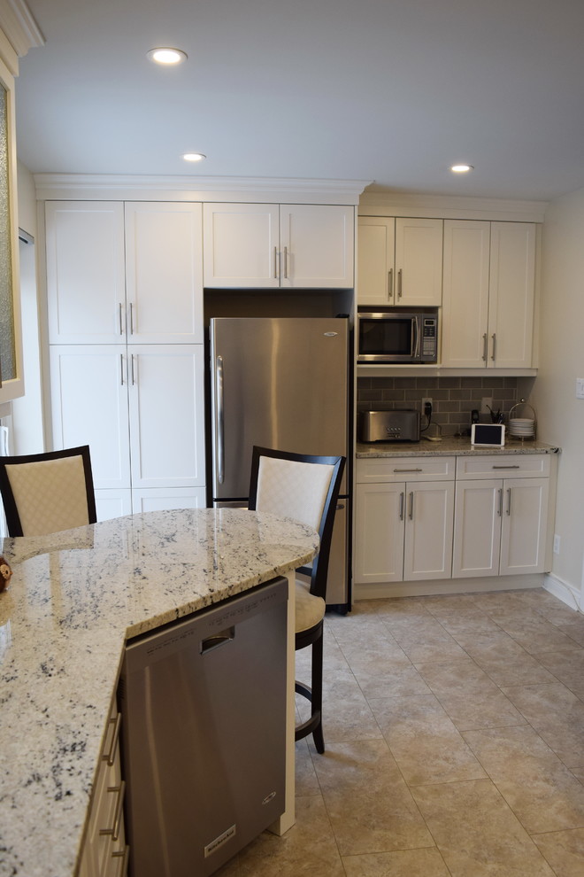 Mid-sized transitional u-shaped ceramic tile enclosed kitchen photo in Ottawa with an undermount sink, shaker cabinets, white cabinets, granite countertops, gray backsplash, glass tile backsplash, stainless steel appliances and a peninsula