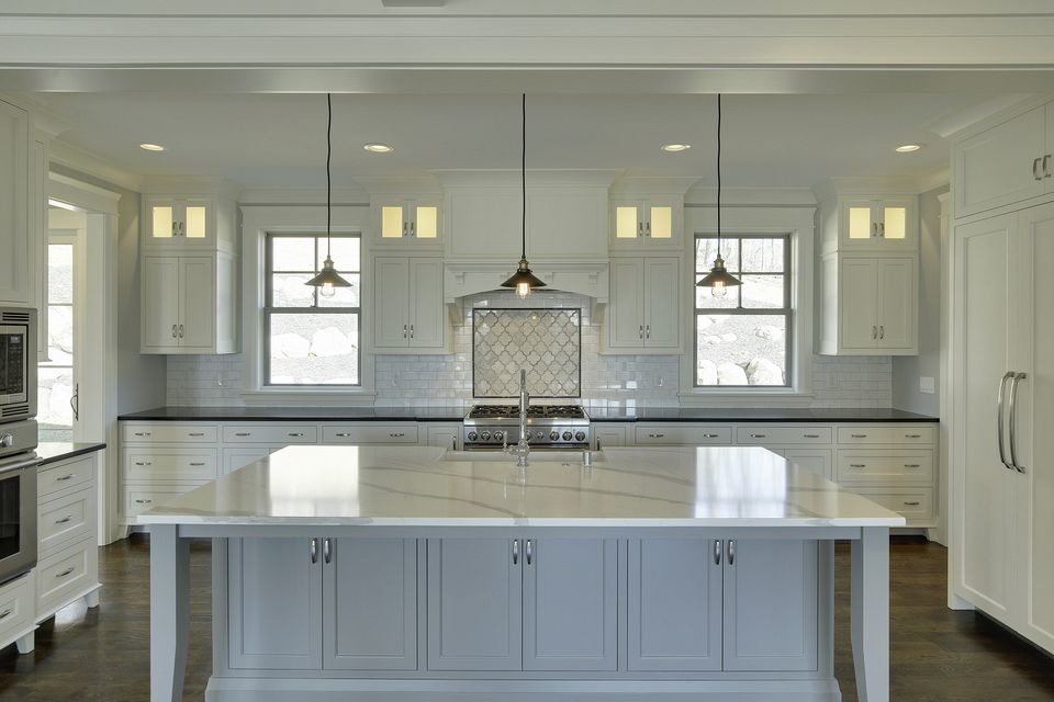 Inspiration for a large transitional u-shaped open plan kitchen in Minneapolis with a farmhouse sink, shaker cabinets, white cabinets, marble benchtops, white splashback, marble splashback, panelled appliances, dark hardwood floors and with island.