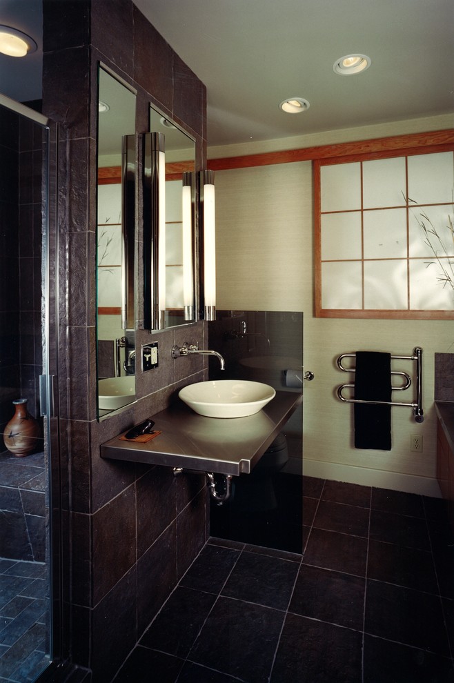 Photo of a mid-sized asian master bathroom in Other with black tile, ceramic tile, beige walls, ceramic floors, a vessel sink, stainless steel benchtops, black floor, a shower seat and a single vanity.