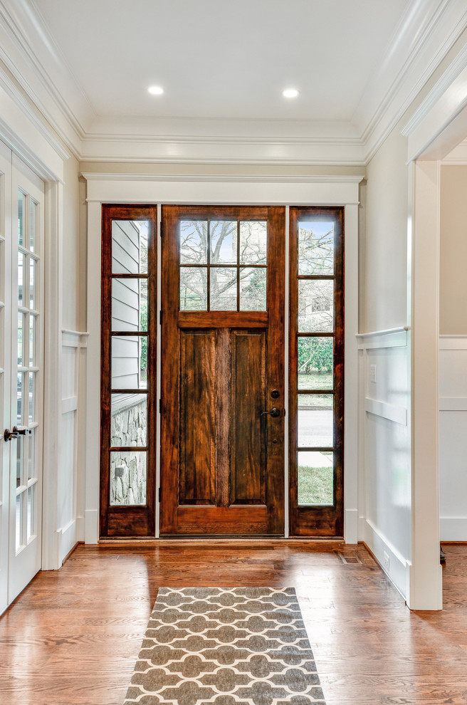 Example of a mid-sized transitional medium tone wood floor and brown floor entry hall design in DC Metro with beige walls