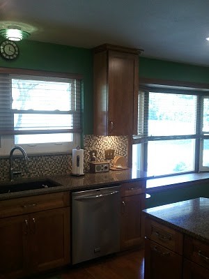 Example of a mid-sized transitional u-shaped medium tone wood floor eat-in kitchen design in Cincinnati with an undermount sink, flat-panel cabinets, medium tone wood cabinets, quartz countertops, multicolored backsplash, mosaic tile backsplash, stainless steel appliances and an island