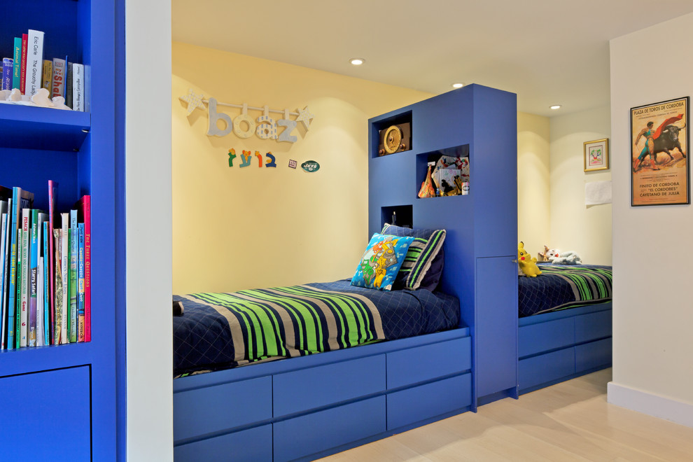 Mid-sized modern kids' bedroom in New York with yellow walls and light hardwood floors for kids 4-10 years old and boys.