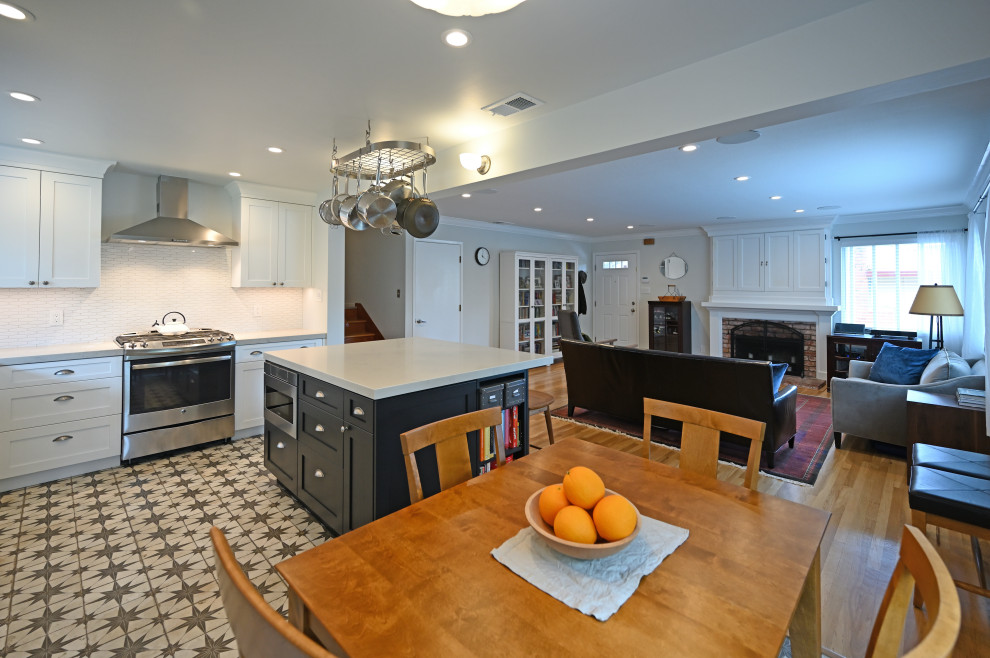 Mid-sized transitional l-shaped porcelain tile and brown floor eat-in kitchen photo in San Francisco with an undermount sink, shaker cabinets, black cabinets, quartz countertops, white backsplash, ceramic backsplash, stainless steel appliances, an island and white countertops