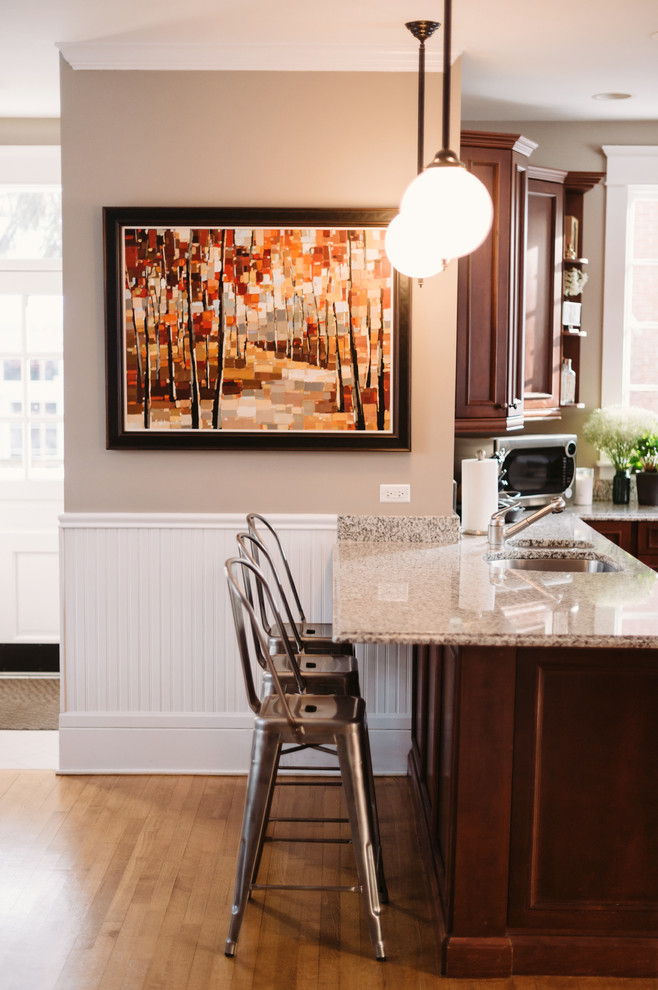 Eat-in kitchen - large transitional u-shaped medium tone wood floor eat-in kitchen idea with recessed-panel cabinets, brown cabinets, granite countertops, metallic backsplash, subway tile backsplash, stainless steel appliances and gray walls