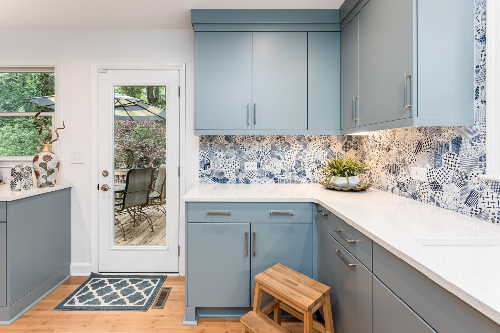 Stilmix Küche mit flächenbündigen Schrankfronten, blauen Schränken, Quarzwerkstein-Arbeitsplatte, Rückwand aus Porzellanfliesen, Bambusparkett und weißer Arbeitsplatte in Raleigh