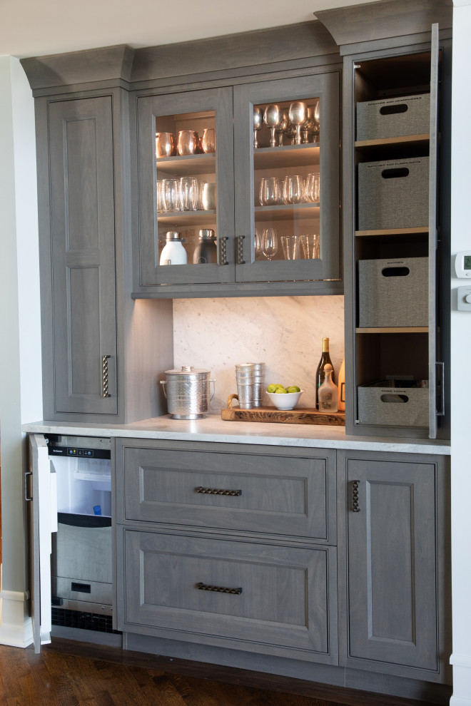 This is an example of a small eclectic galley home bar in Milwaukee with no sink, beaded inset cabinets, grey cabinets, quartzite benchtops, white splashback, stone slab splashback, dark hardwood floors, brown floor and white benchtop.