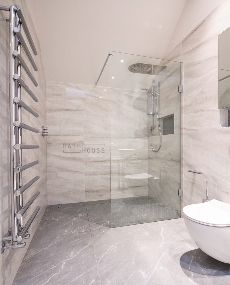 This is an example of a mid-sized modern kids wet room bathroom in Dublin with flat-panel cabinets, a wall-mount toilet, white tile, porcelain tile, white walls, porcelain floors, a vessel sink, glass benchtops, black floor, an open shower and white benchtops.