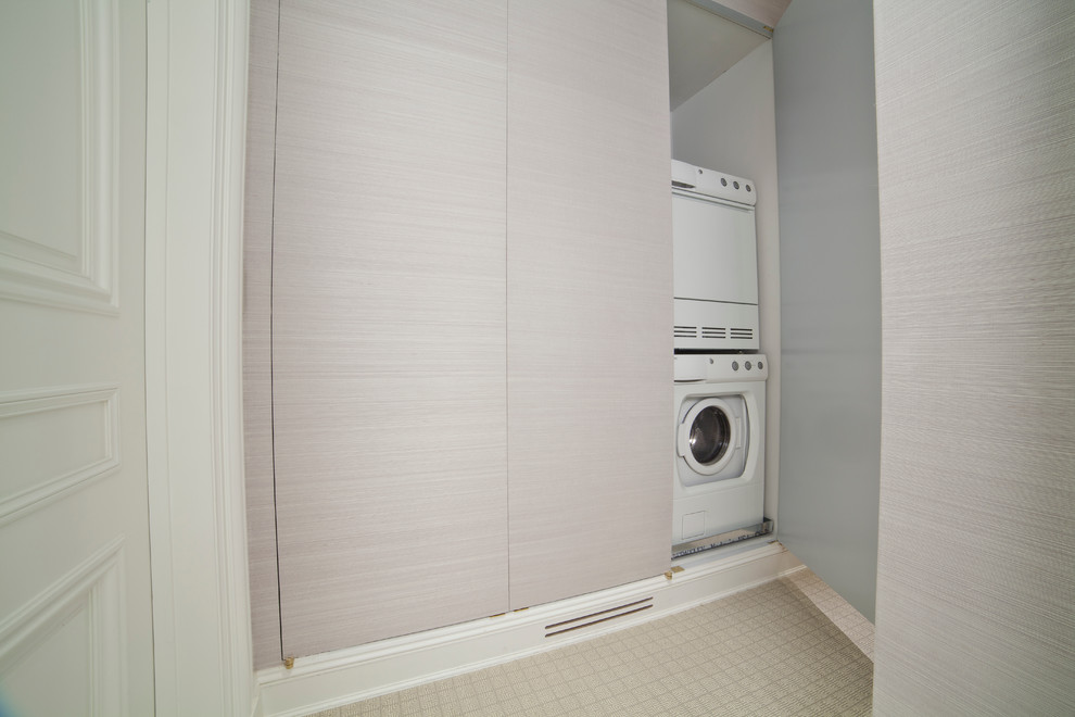 This is an example of a small modern single-wall laundry cupboard in New York with recessed-panel cabinets, white cabinets, granite benchtops, grey walls and ceramic floors.