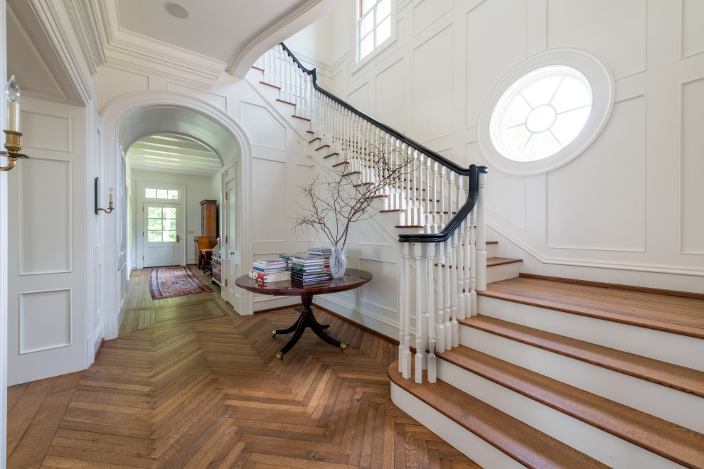 This is an example of a large classic wood l-shaped wood railing staircase in Atlanta with panelled walls.