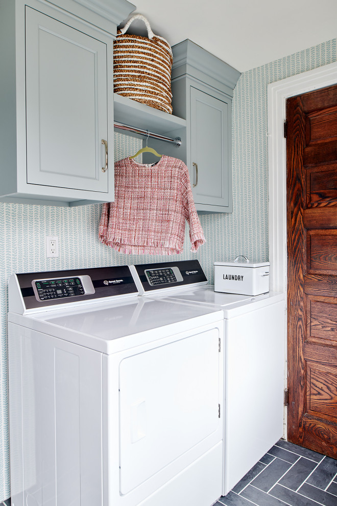 Small eclectic galley utility room in Philadelphia with shaker cabinets, grey cabinets, blue walls, ceramic floors, a side-by-side washer and dryer, black floor and wallpaper.
