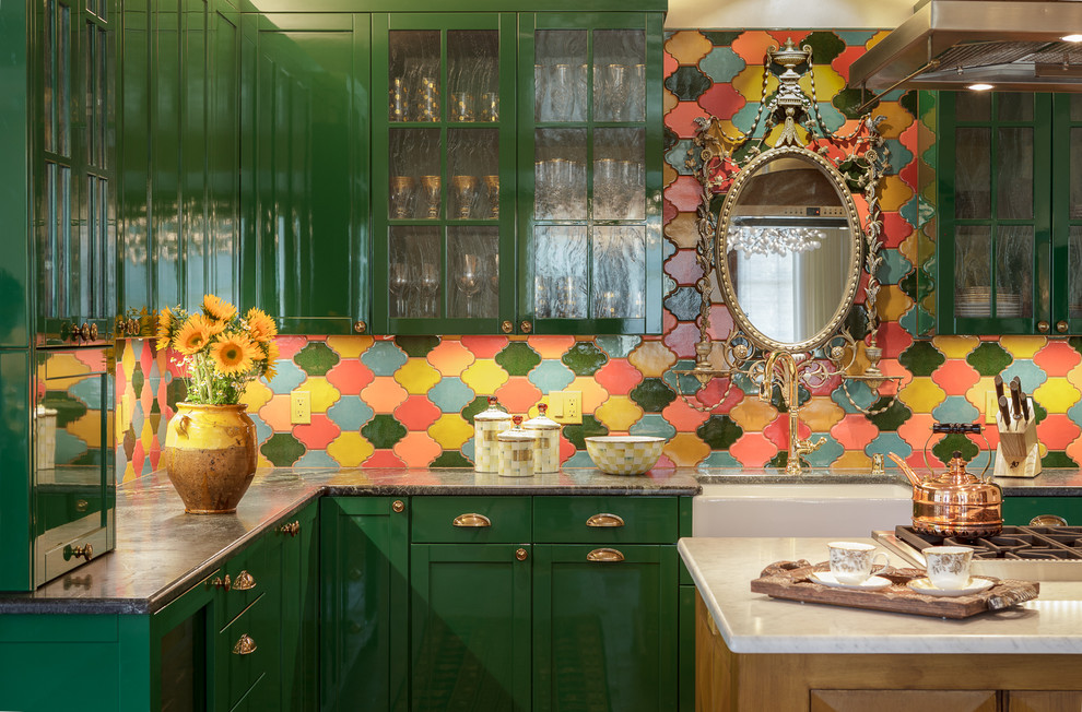 This is an example of a mid-sized eclectic open plan kitchen in Orange County with a farmhouse sink, glass-front cabinets, green cabinets, multi-coloured splashback, ceramic splashback and with island.