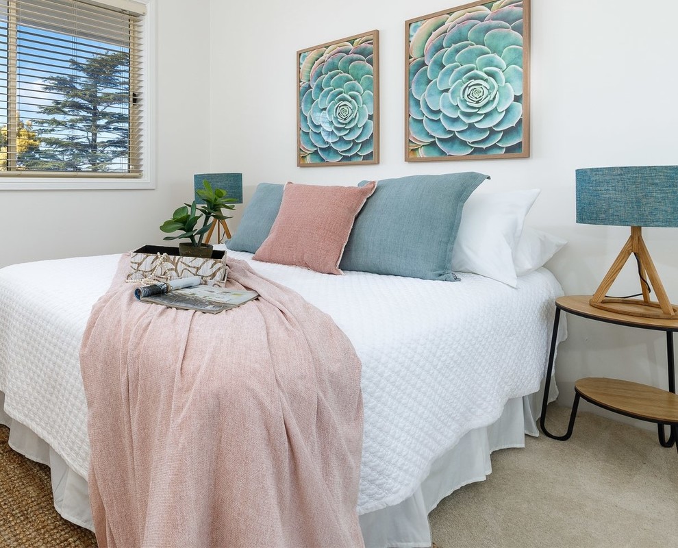 Design ideas for a small beach style guest bedroom in Sydney with white walls, carpet and beige floor.