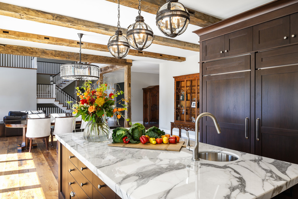 Inspiration for an expansive traditional u-shaped eat-in kitchen in Ottawa with a farmhouse sink, shaker cabinets, dark wood cabinets, marble benchtops, white splashback, mosaic tile splashback, panelled appliances, medium hardwood floors and with island.
