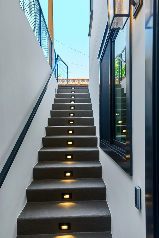 Foto de escalera recta de estilo americano de tamaño medio con escalones de hormigón, contrahuellas de hormigón y barandilla de metal