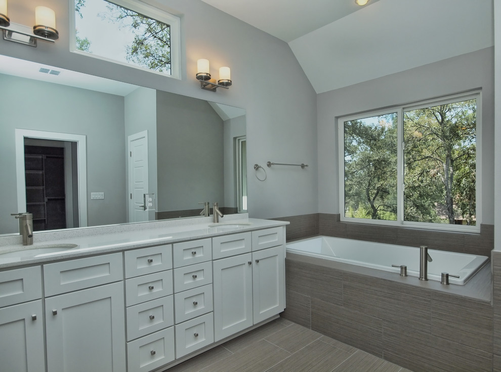 Inspiration for a transitional gray tile and porcelain tile porcelain tile drop-in bathtub remodel in Austin with shaker cabinets, quartzite countertops and gray walls