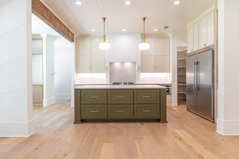 Design ideas for a beach style eat-in kitchen in Other with a farmhouse sink, shaker cabinets, green cabinets, quartzite benchtops, engineered quartz splashback, stainless steel appliances, light hardwood floors, with island, brown floor, white benchtop and timber.