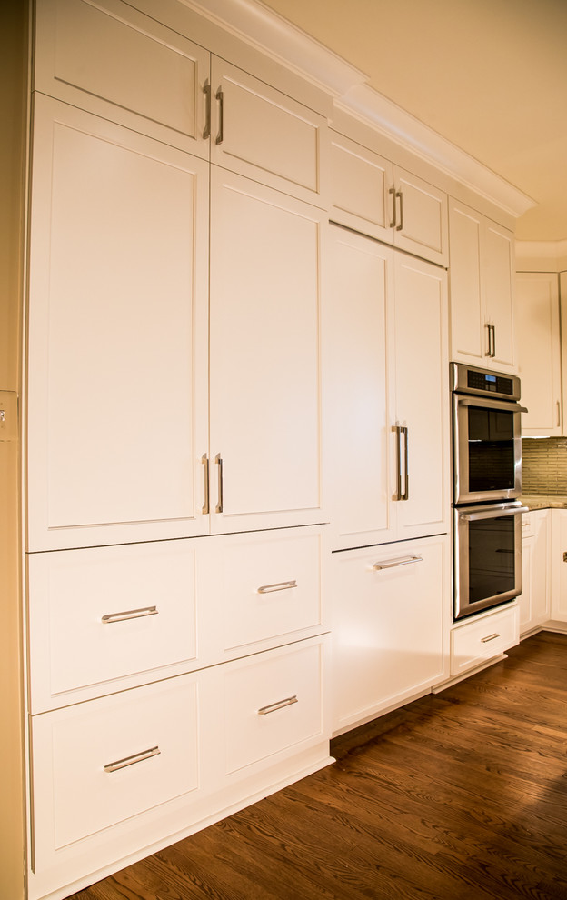 This is an example of a mid-sized transitional l-shaped eat-in kitchen in Baltimore with a double-bowl sink, shaker cabinets, white cabinets, soapstone benchtops, grey splashback, matchstick tile splashback, stainless steel appliances, medium hardwood floors and with island.