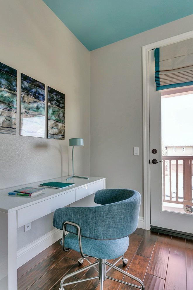 Example of a mid-sized trendy medium tone wood floor bedroom design in Los Angeles with gray walls and no fireplace