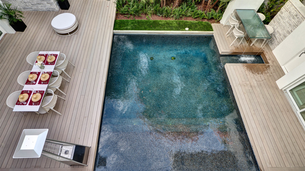 Inspiration for a mid-sized contemporary courtyard rectangular pool in Orlando with a water feature and decking.