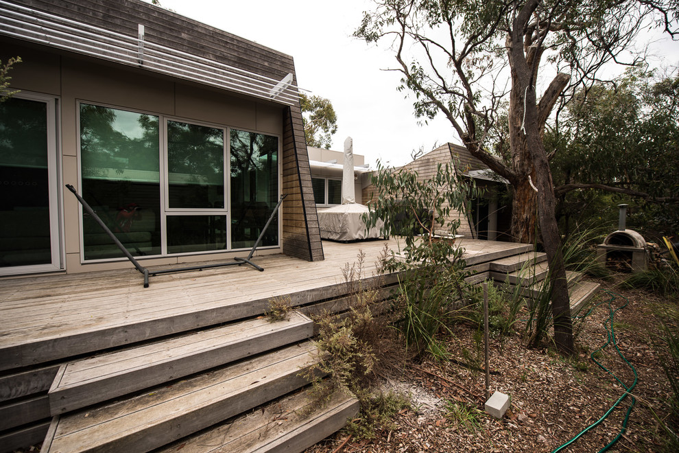 Photo of a large contemporary backyard patio in Melbourne with an awning.