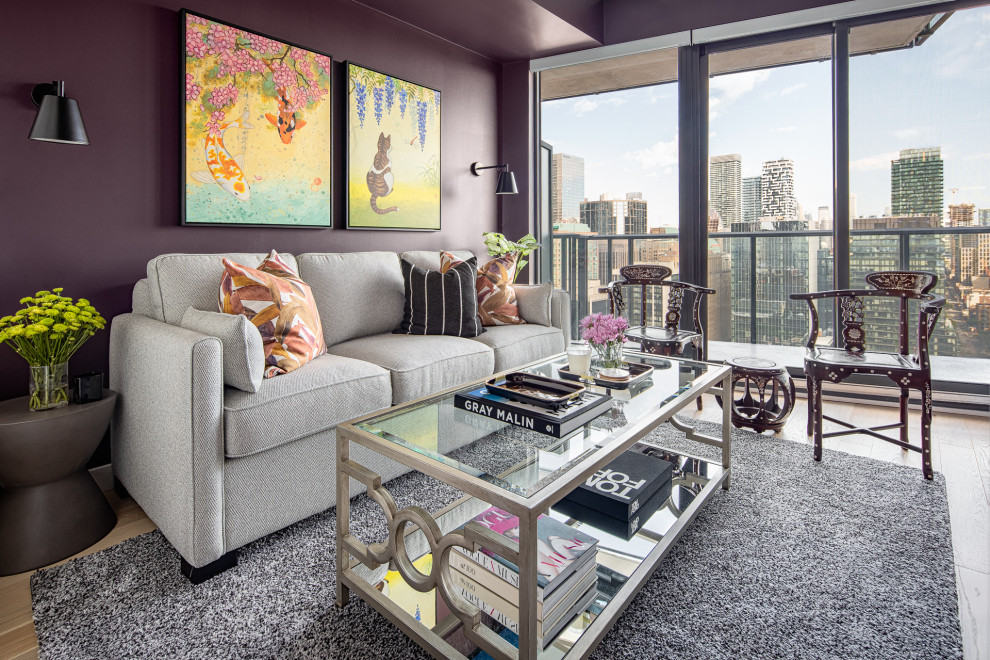 Immagine di una camera degli ospiti contemporanea di medie dimensioni con pareti viola, parquet chiaro e pavimento beige