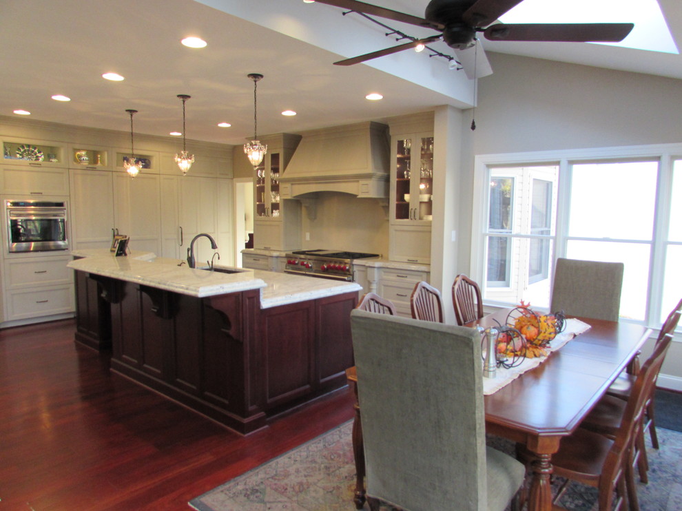 Large transitional l-shaped medium tone wood floor eat-in kitchen photo in DC Metro with an undermount sink, dark wood cabinets, granite countertops, stainless steel appliances and an island