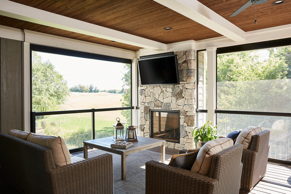 Large classic screened-in back porch idea in Minneapolis with decking and a roof extension