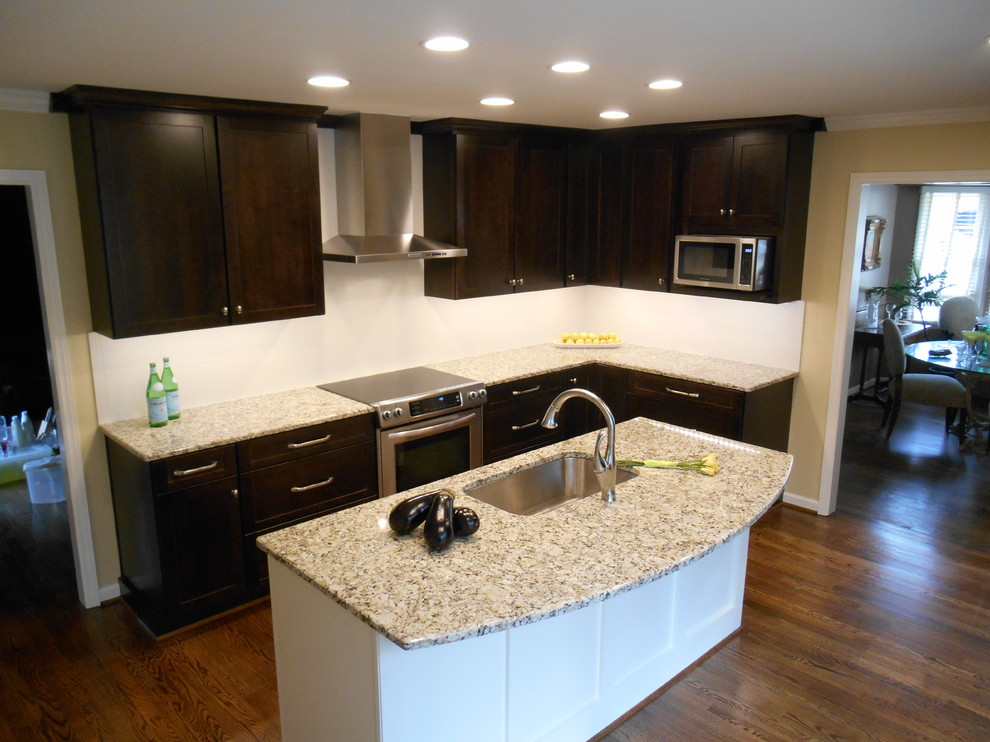 Inspiration for a mid-sized transitional u-shaped eat-in kitchen remodel in Birmingham with an undermount sink, shaker cabinets, dark wood cabinets, granite countertops, white backsplash, ceramic backsplash and stainless steel appliances