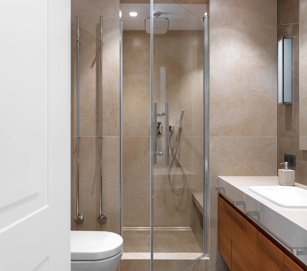 Photo of a mid-sized contemporary 3/4 bathroom in Other with flat-panel cabinets, dark wood cabinets, beige tile, porcelain tile, porcelain floors, tile benchtops, a hinged shower door, beige benchtops, an alcove shower, a drop-in sink and beige floor.