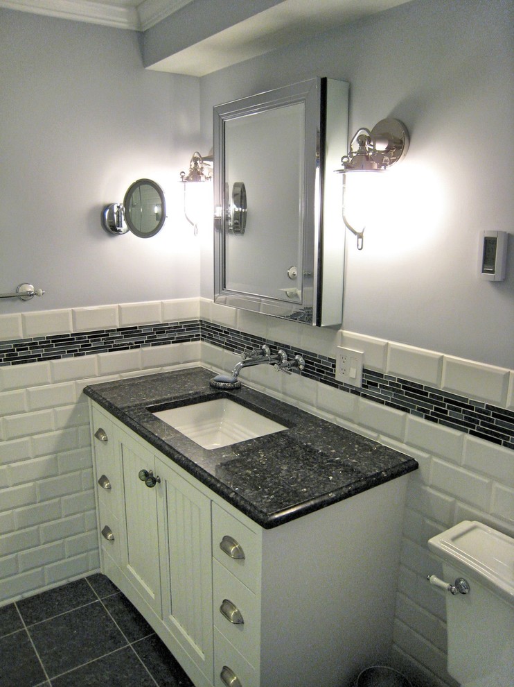 Mid-sized transitional 3/4 white tile and ceramic tile porcelain tile and black floor bathroom photo in Providence with recessed-panel cabinets, white cabinets, a two-piece toilet, gray walls, an undermount sink, granite countertops and black countertops