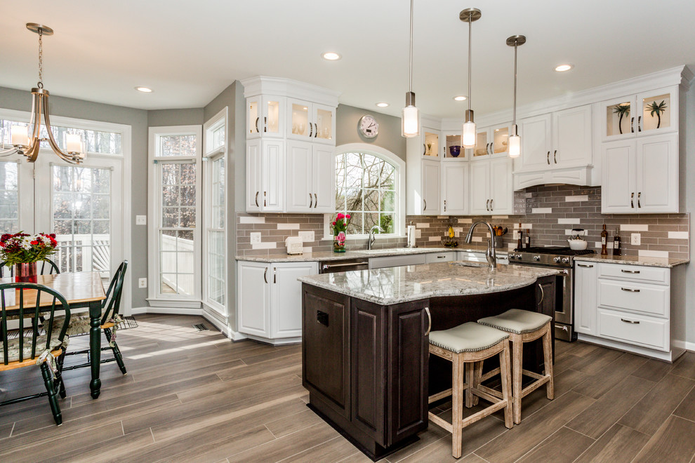 Inspiration for a large transitional u-shaped porcelain tile and brown floor eat-in kitchen remodel in DC Metro with a single-bowl sink, raised-panel cabinets, white cabinets, quartz countertops, gray backsplash, ceramic backsplash, stainless steel appliances and an island