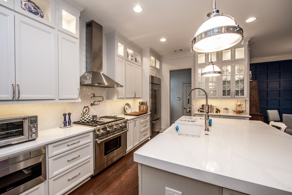 Inspiration for a large country separate kitchen in Atlanta with a farmhouse sink, flat-panel cabinets, white cabinets, quartz benchtops, white splashback, ceramic splashback, stainless steel appliances, dark hardwood floors, with island and white benchtop.