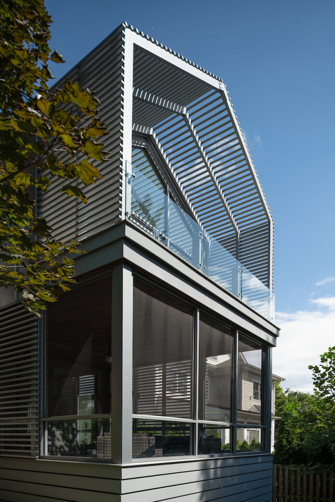 Idéer för en stor modern innätad veranda på baksidan av huset, med takförlängning och räcke i metall