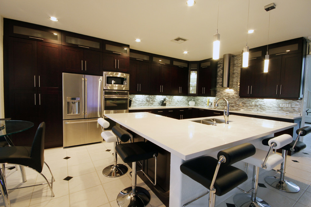 This is an example of a contemporary l-shaped eat-in kitchen in Miami with an undermount sink, shaker cabinets, brown cabinets, quartzite benchtops, metallic splashback and stainless steel appliances.