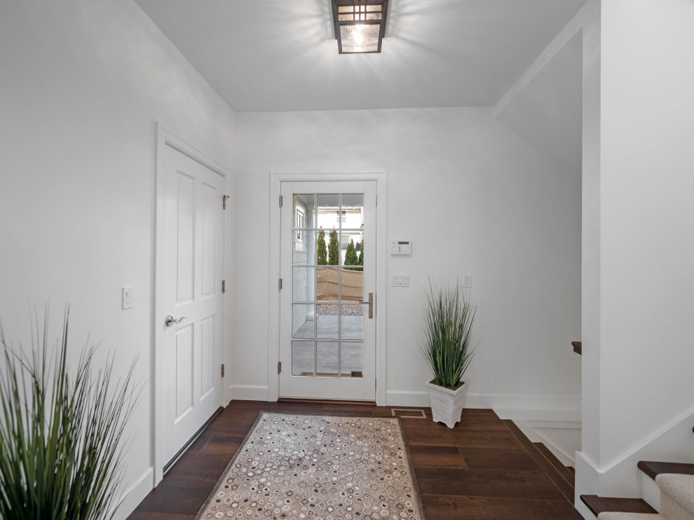 Design ideas for a mid-sized traditional foyer in Grand Rapids with white walls, medium hardwood floors, a single front door, a glass front door and brown floor.