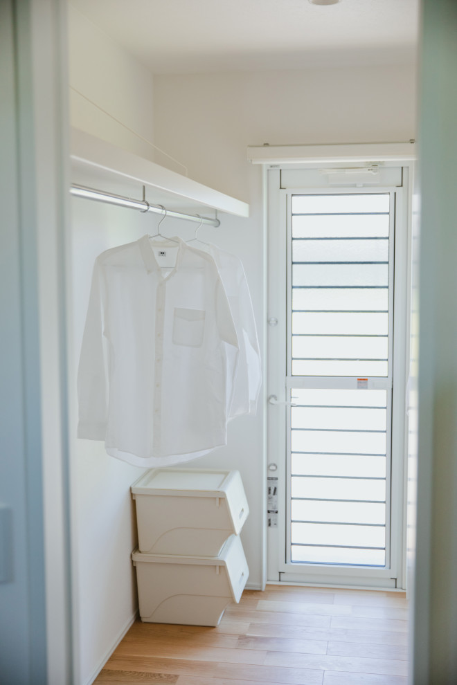 Photo of a country gender neutral walk-in wardrobe in Other with medium hardwood flooring, brown floors and a wallpapered ceiling.