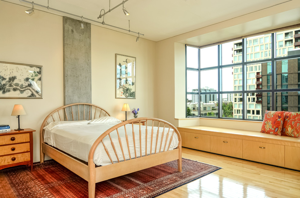 Foto de dormitorio contemporáneo con paredes beige, suelo de madera clara y suelo beige