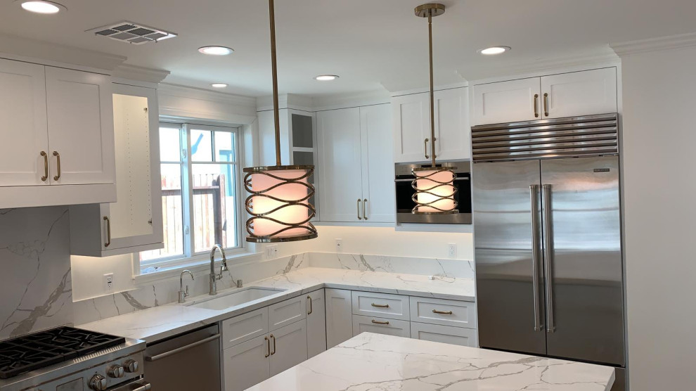 Inspiration for a mid-sized modern l-shaped kitchen in Los Angeles with a single-bowl sink, shaker cabinets, white cabinets, marble benchtops, white splashback, timber splashback, stainless steel appliances and with island.