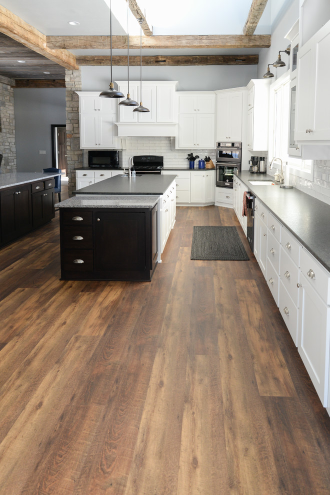 Kitchen - vinyl floor and brown floor kitchen idea with recessed-panel cabinets, white cabinets, white backsplash and ceramic backsplash